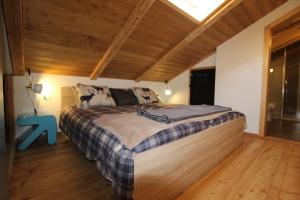 バート・クラインキルヒハイムにあるRoZa´s Nest by Isa Badkleinkirchheimの木製の天井のベッドルーム1室(大型ベッド1台付)