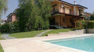 a house with a swimming pool in front of a house at Appartamenti Villacedro in Lazise