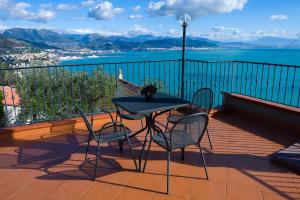 a table and chairs on a balcony with a view of the water at Il Glicine in Cetara