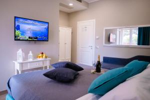 a bedroom with a bed with pillows and a flat screen tv at Relais Villa Italia in Selcetta