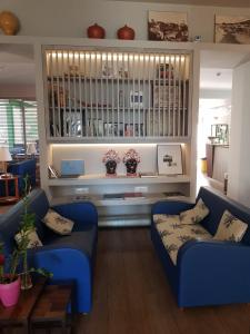 a living room with two blue couches and a table at Hotel Lucerna in Castiglione della Pescaia