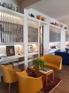 a living room with a couch and a table and chairs at Hotel Lucerna in Castiglione della Pescaia