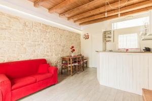a living room with a red couch and a table at SANT'ANDREA APARTMENT in Molfetta