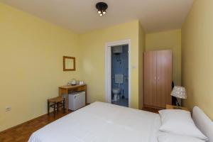 ein Schlafzimmer mit einem weißen Bett und ein Badezimmer in der Unterkunft Beautiful Nest Rooms in Dubrovnik