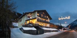 a large building on a snow covered street with a building at Hotel Loredana in Livigno