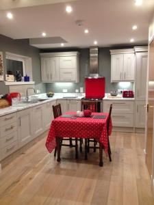 a kitchen with a table with a red table cloth at Blossom Folly in Dunvegan