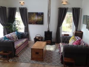 ein Wohnzimmer mit 2 Sofas und einem Couchtisch in der Unterkunft Blossom Folly in Dunvegan