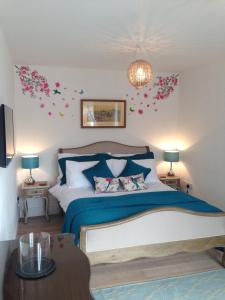 ein Schlafzimmer mit einem Bett mit blauer Bettwäsche und Blumen an der Wand in der Unterkunft Blossom Folly in Dunvegan