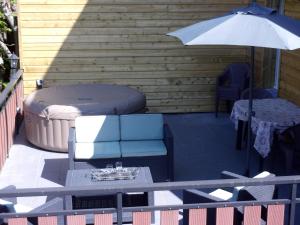 a patio with a couch and an umbrella and a table at chez Andréa in Le Mont-Dore +7 photos