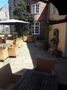 a patio with chairs and a table and an umbrella at Langport Arms Hotel in Langport