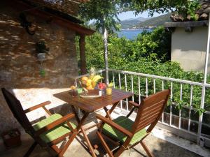 una mesa de madera con una cesta de fruta en el balcón en Apartments Solitudo, en Dubrovnik