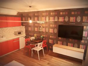 uma cozinha com mesa e cadeiras e uma televisão em City Apartments em Eilat