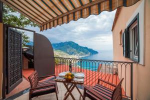 un balcone con tavolo e sedie e vista sull'oceano di Le Esperidi a Ravello