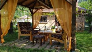 a wooden table and chairs under a gazebo at Lion Cottage in Chuprene