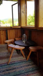 Chuprene的住宿－Lion Cottage，窗户间的桌子和长凳