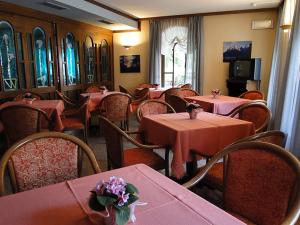 a restaurant with tables and chairs with pink tablecloths at Albergo Dolomiti in Fiera di Primiero