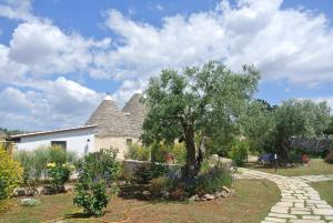 una casa con un árbol en un jardín en Trulli Paparale, en Alberobello