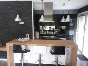a kitchen with a wooden table and black walls at les rainettes in Grand-Halleux