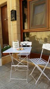 two white chairs and a table and a table and chairs at Appartamento urban in Custonaci