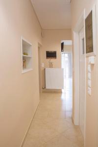 a hallway with a white wall and a radiator at Remezzo Apartments in Akrogiali