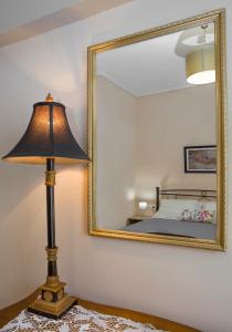 une lampe assise sur une table devant un miroir dans l'établissement Remezzo Apartments, à Akrogiali