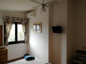 a bedroom with a ceiling fan and a window at La Lantana Nuova in Flumini di Quartu