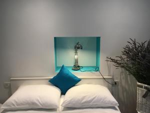 un letto con 2 cuscini e una lampada a muro di Adria a Fiume (Rijeka)