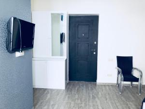 a room with a black door and a chair and a tv at Tini's Apartment in Gonio +4 photos
