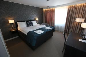 una camera d'albergo con un letto e due asciugamani di Hotell Rättvik a Rättvik
