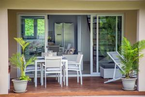 un tavolo e sedie su un portico con piante di Villas Coco Beach Praslin ad Anse Kerlan