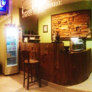 a bar in a restaurant with a counter and a refrigerator at login homestay in Madiun
