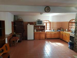 a kitchen with a white refrigerator and a clock on the wall at Casa COLT DE RAI in Brezoi