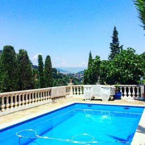 ein Pool mit zwei Stühlen daneben in der Unterkunft Bastide Provencal in Théoule-sur-Mer