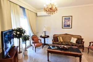 - un salon avec un canapé et une télévision dans l'établissement Queens Bed&Rest Luxury Apartment, à Kavala
