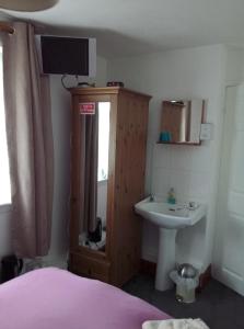 um quarto com uma cama, um lavatório e um espelho em Maggie's em Inveraray