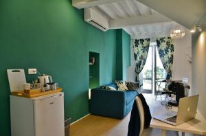 a living room with green walls and a blue couch at Pieve Suites in Città della Pieve