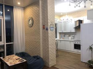 un soggiorno con parete in mattoni e una cucina di Zhemchuzhnie apartments on Marselskaya a Odessa