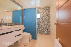 La salle de bains est pourvue de toilettes et d'une douche bleue. dans l'établissement Pon Pon Wu Homestay, à Magong