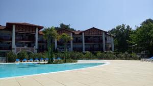 a large apartment building with a large swimming pool at Appartement dans résidence de vacances in Biscarrosse