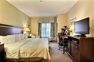a hotel room with a bed and a flat screen tv at Magnolia Inn and Suites Pooler in Savannah