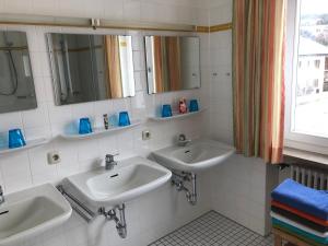 a bathroom with two sinks and two mirrors at Mittenwald-Ferien in Mittenwald +70 photos