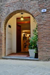 un accès à un bâtiment en briques avec une porte et une usine dans l'établissement Pieve Suites, à Città della Pieve