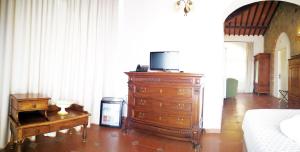 a tv sitting on top of a wooden table in a room at La Loggia - Villa Gloria -Adults Only in Quercegrossa