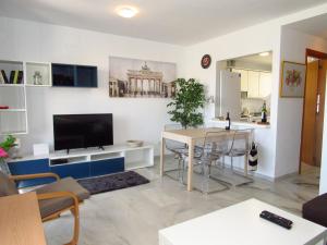 a living room with a television and a table at Lomas de Mena in Benalmádena