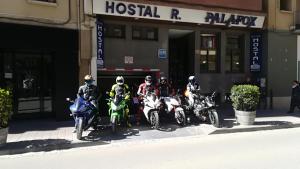 um grupo de pessoas em motocicletas estacionadas em frente a um edifício em Hostal Palafox em Barbastro