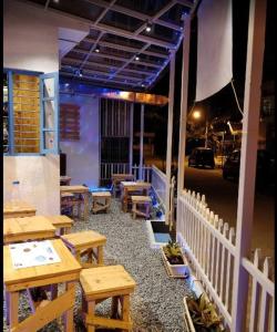 a patio with wooden tables and benches on a street at Transit Dorms - A Backpackers Inn & Hostel in Bangalore