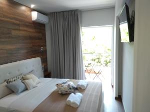 um quarto com uma cama branca e uma grande janela em Limonchello em Kalamata