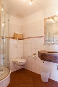 a bathroom with a toilet and a sink and a tub at Hotel Backenköhler in Ganderkesee