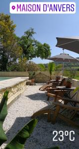 a group of tables and umbrellas on a patio at Maison d'Anvers in Valréas