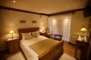 a bedroom with a large bed and two lamps and a window at Quinta de CasalMato in Resende